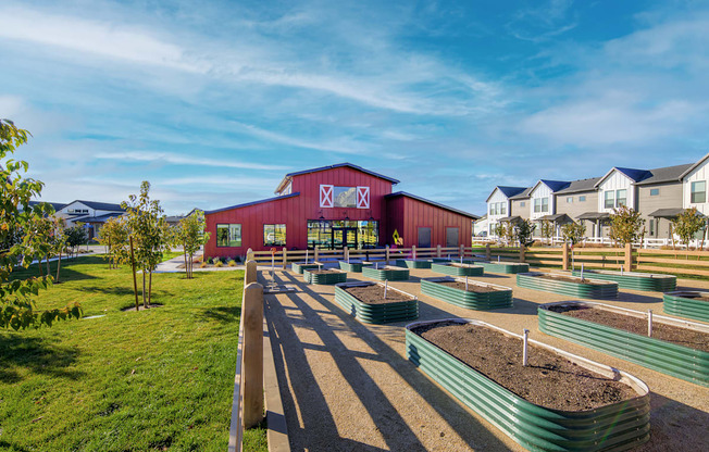a community garden in front of a red barn