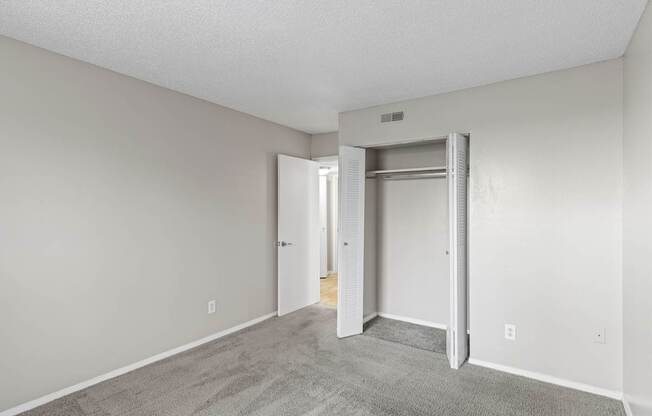 A room with a carpeted floor and a white door.