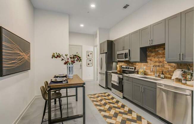 A kitchen with a table and chairs and a painting on the wall.