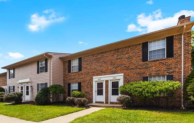 A brick house with a white door and windows.