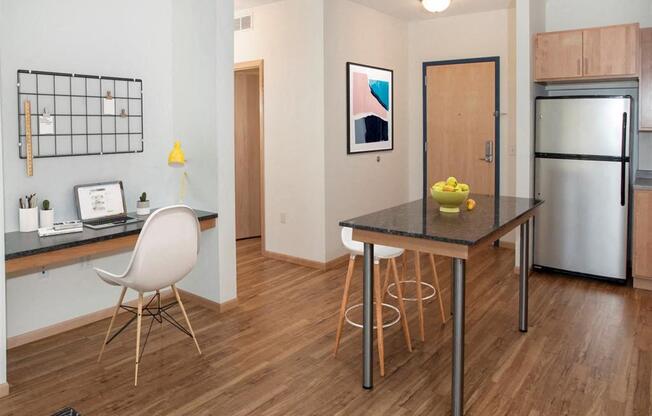 A kitchen with a table and chairs.