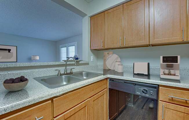 A kitchen with wooden cabinets and a granite countertop.