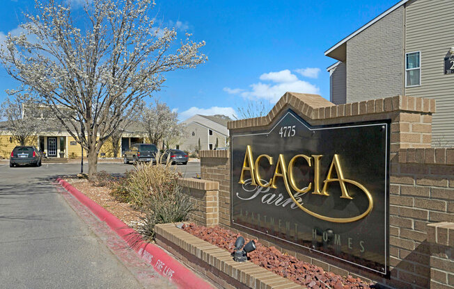 A welcoming community entrance sign at Acacia Park featuring clear signage, landscaped surroundings, mature trees, and a bright, well-kept setting that creates an inviting first impression for residents and guests.