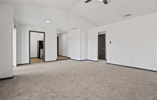 an empty living room with white walls and carpet