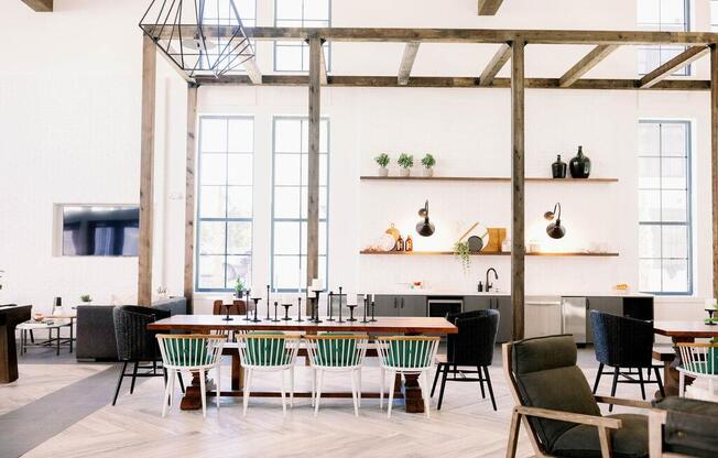 Resident lounge with high ceilings and wooden pergola with various cafe seating and farm tables at The Merchant Apartments, South Carolina