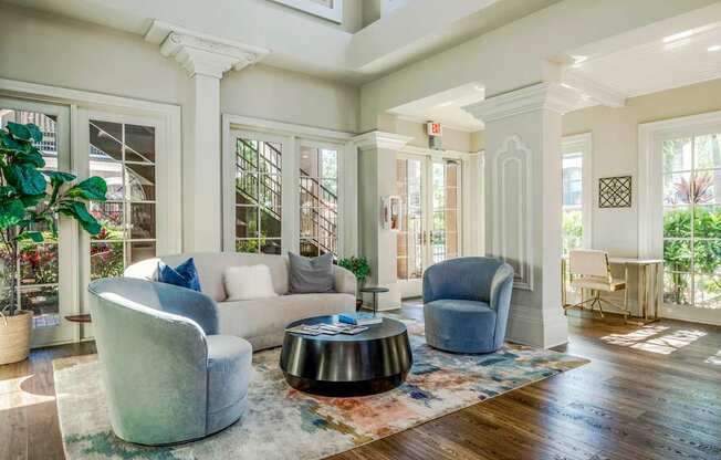 Elegant clubhouse seating area with large windows, plush chairs, and inviting design.