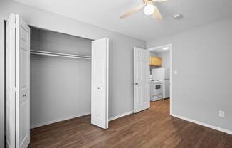an empty living room with wood flooring and a ceiling fan