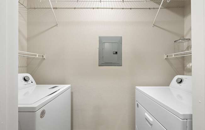 a white laundry room with two washes and a dryer at The Verandah, Texas