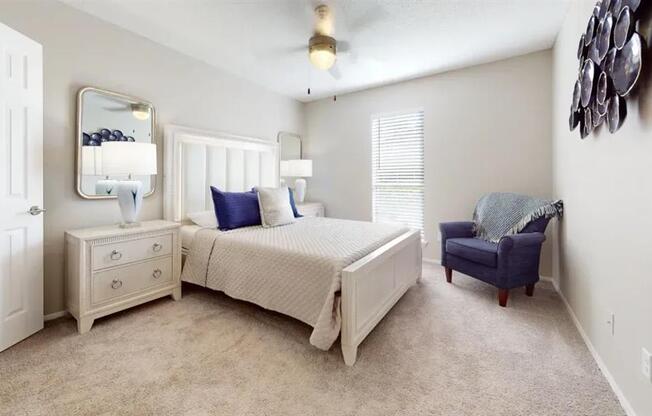 A bedroom with a bed, dresser, and chair.