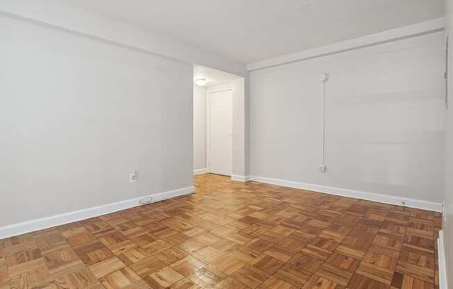 a bedroom with hardwood floors and white walls