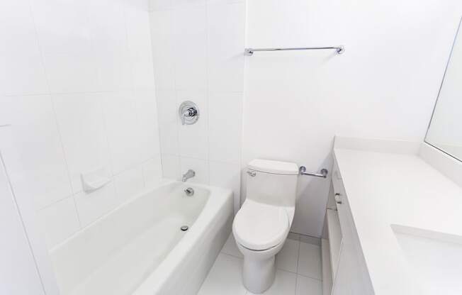 a white toilet sitting next to a bath tub