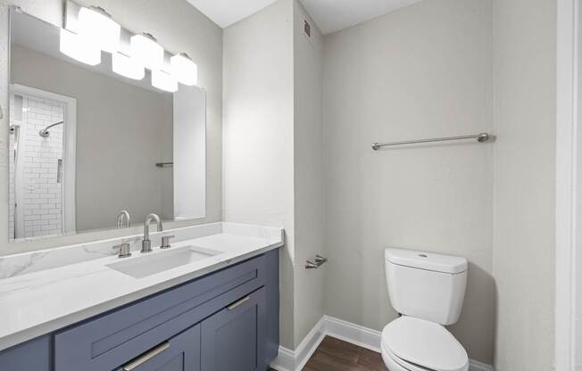 A white toilet sits next to a sink at Dunwoody Glen, Georgia ,30360