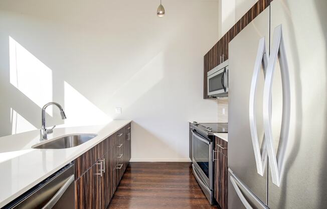 a kitchen with stainless steel appliances and a sink at The Hayes on Stone Way, Seattle, WA