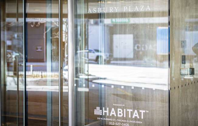 The image shows the entrance to a building with a glass door and a sign that reads