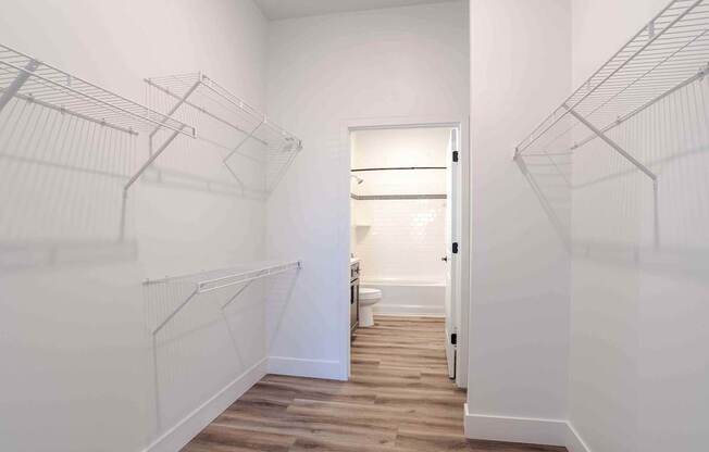 an oversized closet with white walls and wood floors