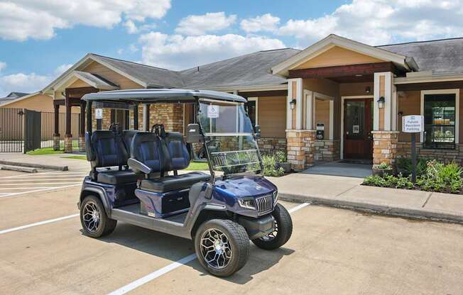 A blue golf cart is parked in front of a building.