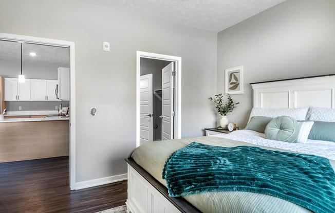A bedroom with a bed, a dresser, and a mirror.