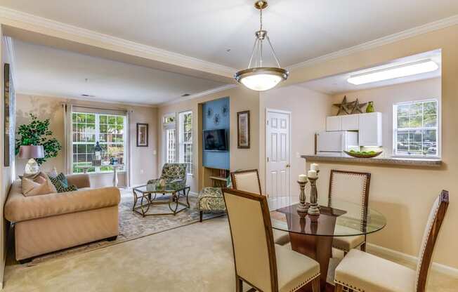 a living room and dining room with a table and chairs