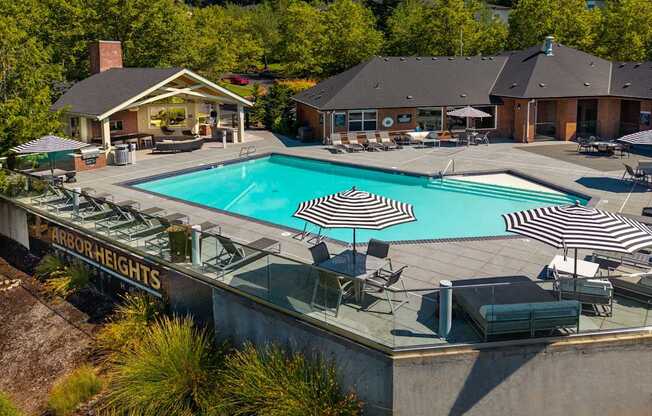 A large outdoor swimming pool with loungers and umbrellas.