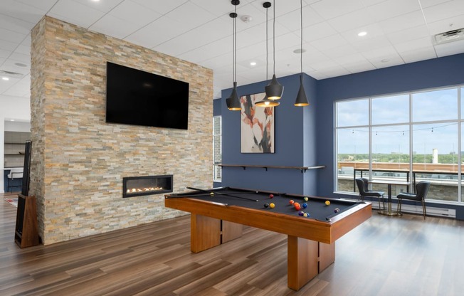 a games room with a pool table and a fireplace