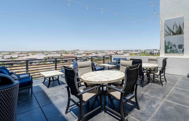 tables and chairs on a rooftop patio with a view of scottsdale arizona