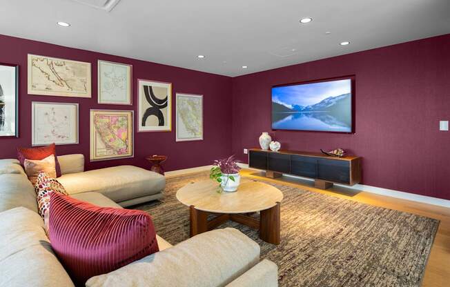 A living room with a red chair and a television.