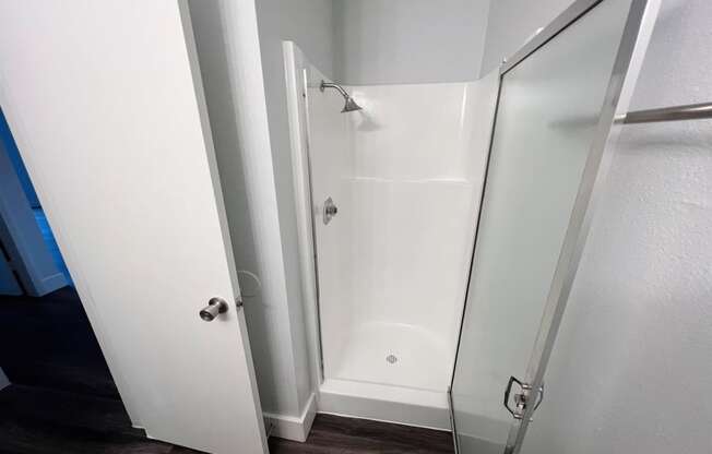 a bathroom with a shower and a sliding glass door