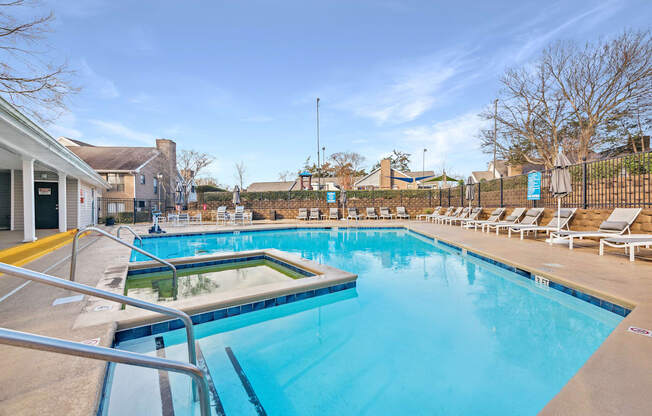 A large outdoor swimming pool with a glass divider and sun loungers.