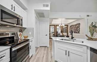 A kitchen with white cabinets and a black stove top oven. at Lazo Apartment Homes, Chandler, 85225
