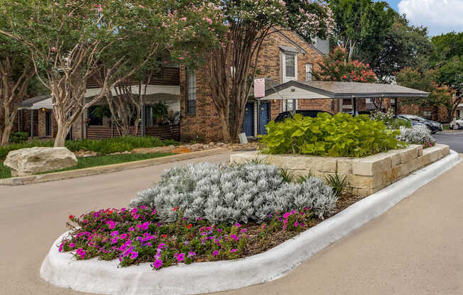 A house with a flower bed in front of it.