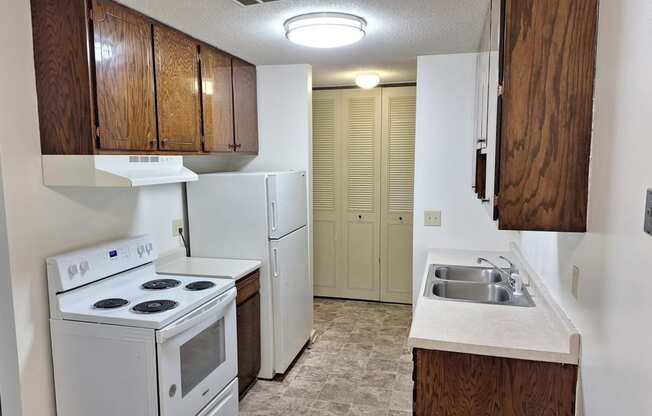 an empty kitchen with a stove refrigerator and sink