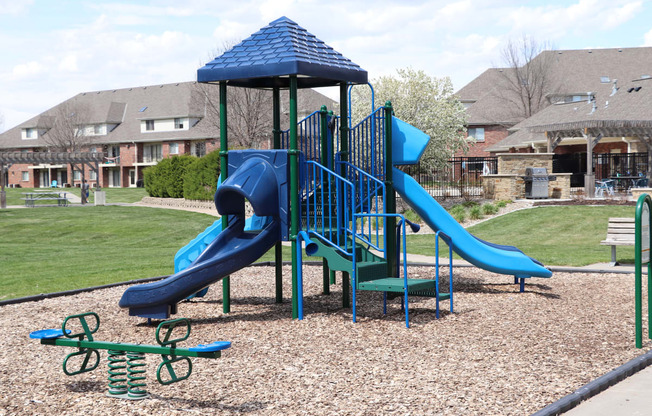 Children's playground with slides and a seesaw at Fountain Glen Apartments in Lincoln, NE