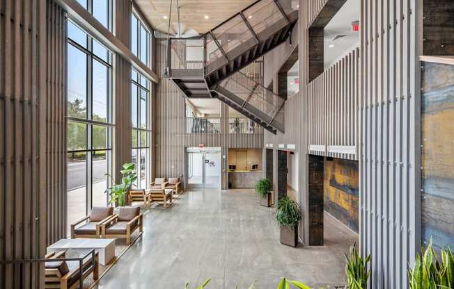 A modern atrium with a staircase and seating area.