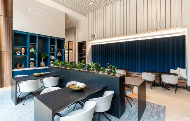 community coworking lounge with blue walls and white chairs and tables at Preston Ridge Apartments Cary, NC