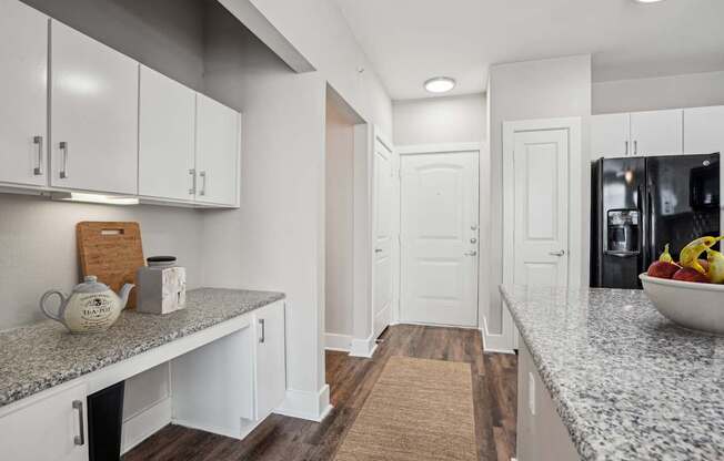 A kitchen with white cabinets and a granite countertop.