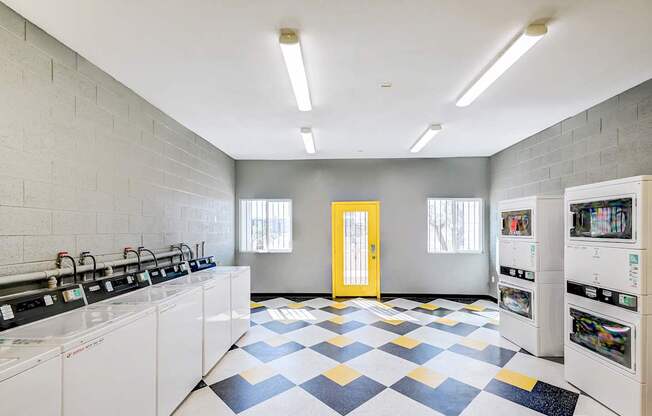 A laundry room with a checkered floor and a yellow door.