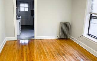 an empty living room with wood floors and a ceiling fan