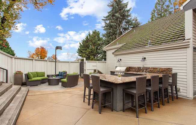 A patio with a table and chairs is surrounded by a white fence.