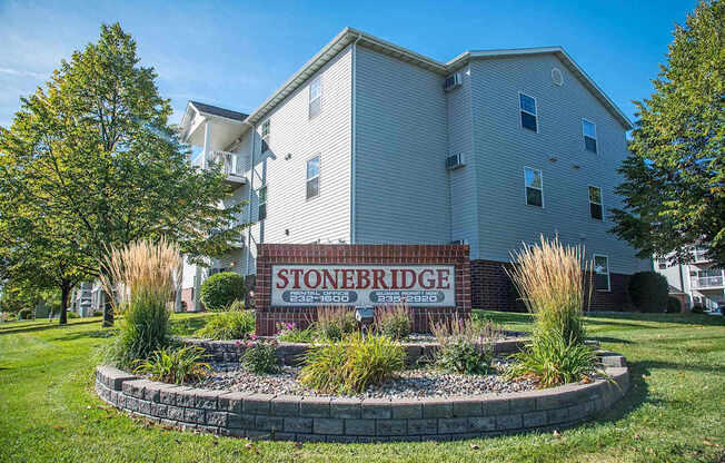 A building with a sign that says Stoneridge in front of it. Fargo, ND Stonebridge Apartments