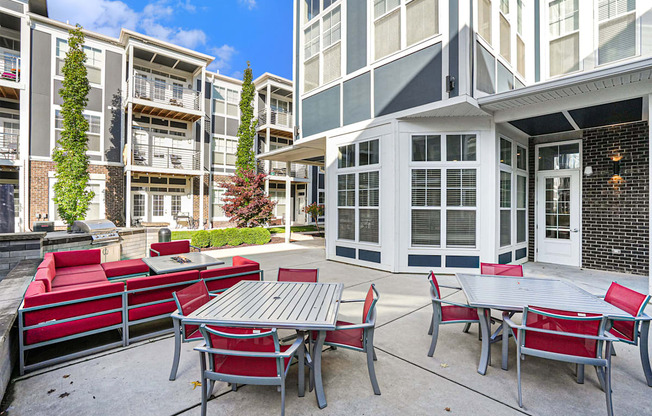 an outdoor patio with tables and chairs at an apartment building