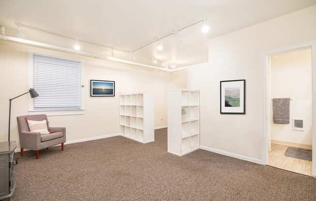 a living room with a couch and a chair and a book shelf