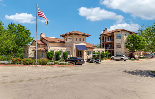 an flag flies in front of a building with a parking lot