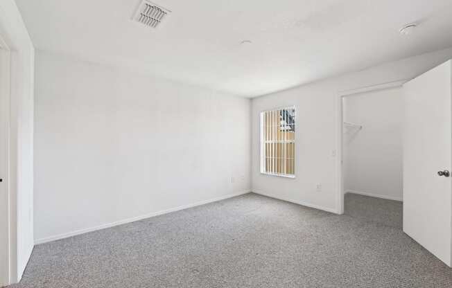 the living room of an apartment with carpet and white walls