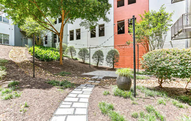 A garden with a stone pathway leading to a building.