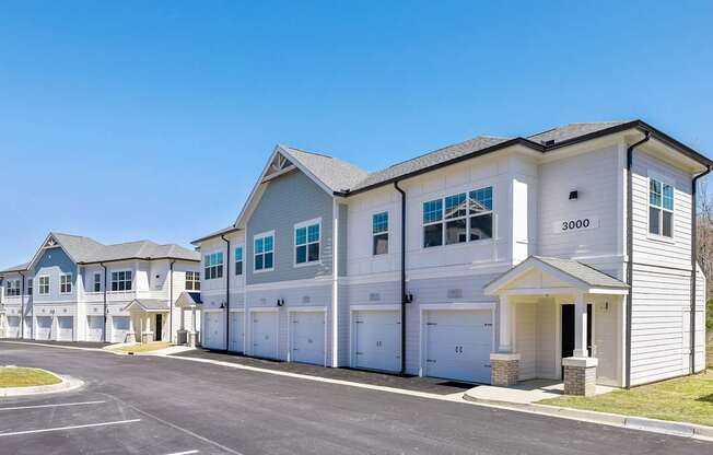 A row of houses with garages and driveways.