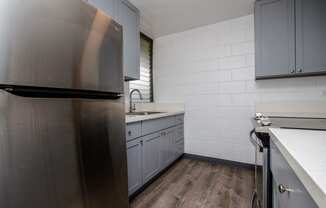 a kitchen with stainless steel appliances and white counter tops at Palms of Kilani Apartments, Wahiawa