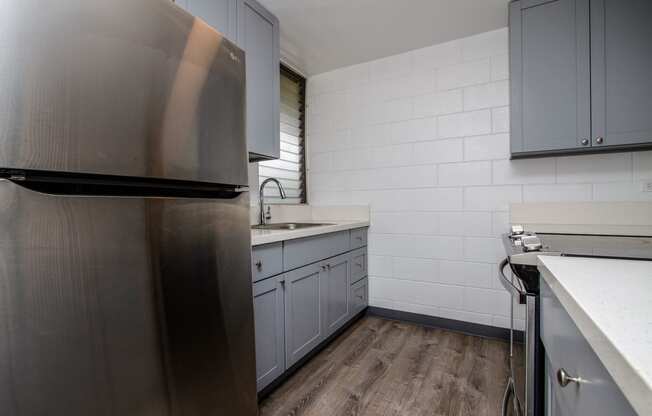 a kitchen with stainless steel appliances and white counter tops at Palms of Kilani Apartments, Wahiawa