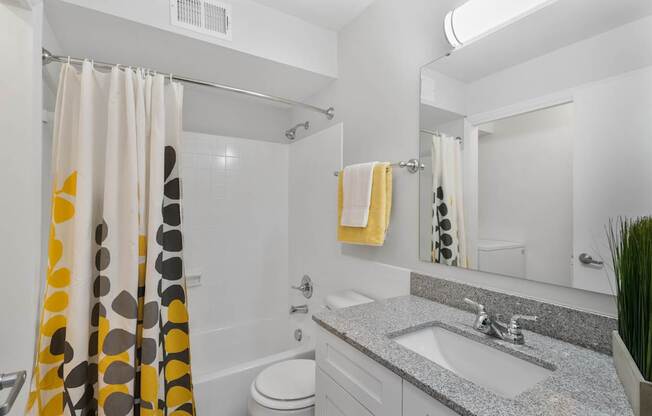 Stylish full bathroom at Monon Living in Broad Ripple featuring granite vanity, designer lighting, and modern tile just minutes from Monon Trail access.