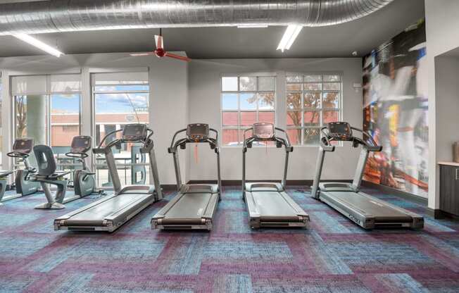 a gym with cardio machines and windows in a building at South Side Flats, Texas