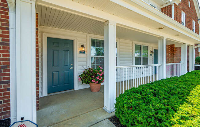 the front porch of a house with a blue door